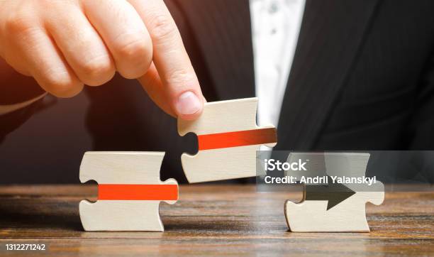 Businessman Inserts The Puzzle And Completes The Assembly Of The Red Arrow Business Process Formation Roadmap Agreement Resuming And Ensuring Uninterrupted Technological Operation Progress Stock Photo - Download Image Now