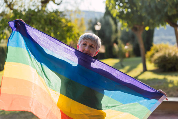 weißhaarige kaukasische erwachsene frau mit lgbt flagge, diversity-konzept - lesbian gay man rainbow multi colored stock-fotos und bilder