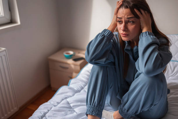 istock Troubled woman holding head in hands while crying in bed 1312272678