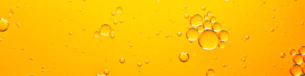 istock oil with bubbles on orange background. 1312275190