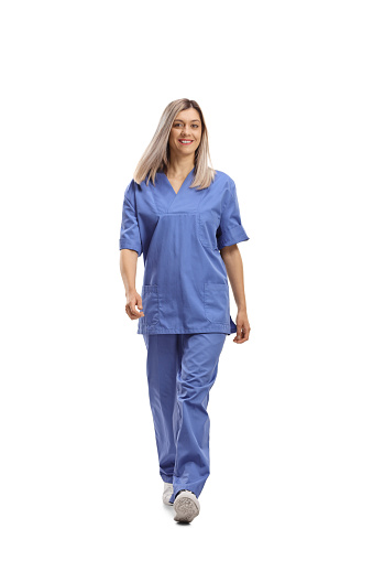 Retrato de larga duración de una trabajadora de la salud con un uniforme azul caminando hacia la cámara photo