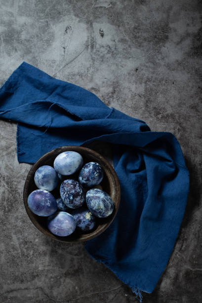 istock eggs are painted with blueberries in the form of a marble pattern. blue Easter eggs lie in a clay bowl on a stone background. 1312275549