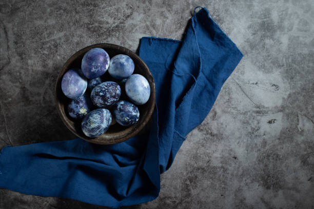 istock eggs are painted with blueberries in the form of a marble pattern. blue Easter eggs lie in a clay bowl on a stone background. 1312276381