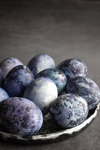 istock organic Easter eggs on a dark background, hand-painted with natural blueberries, lie in a clay cup on a stone table. Easter concept. 1312276988