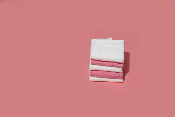 istock Stack of clean soft towels on pink empty space background.Towels stack,female hygiene.Spa concept. 1312277059