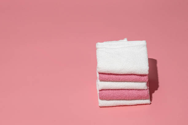 istock Stack of clean soft towels on pink empty space background.Towels stack,female hygiene.Spa concept. 1312277065