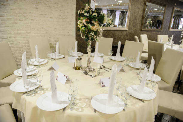 istock table setting in a banquet hall in white color: a round table with flower arrangement on it surrounded by chairs 1312278480