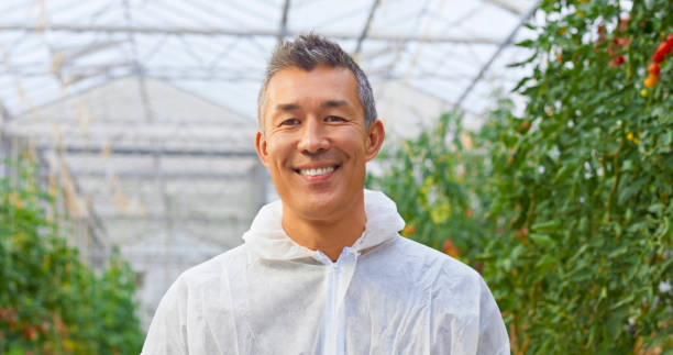 istock Smiling male botanist standing in greenhouse 1312279621
