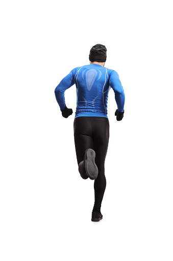 Tiro trasero de cuerpo entero de un hombre con traje de deportes de invierno corriendo photo