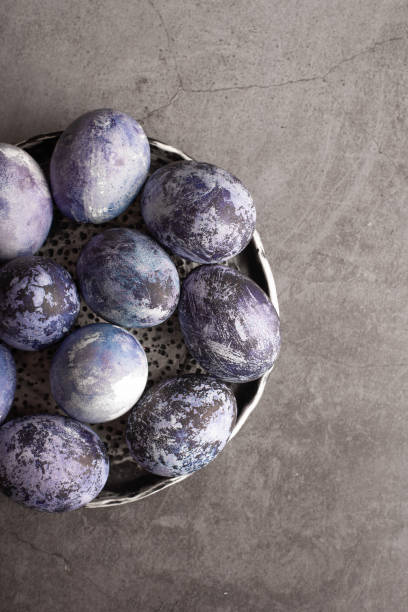 istock marble Easter eggs on a dark background, hand-painted with natural blueberries, lie in a clay cup on a stone table. Easter preparation concept. 1312280910
