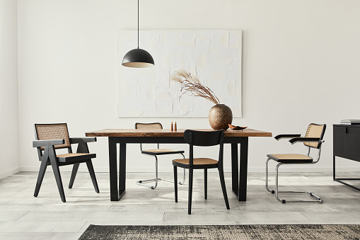 Minimalist composition of dining room interior with wooden table, design chairs and elegant personal accessories. Template.