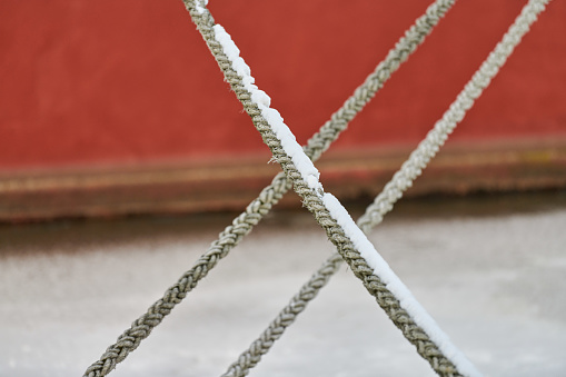 Light blue and white ropes knotted on the deck of a fishing boat. High angle view