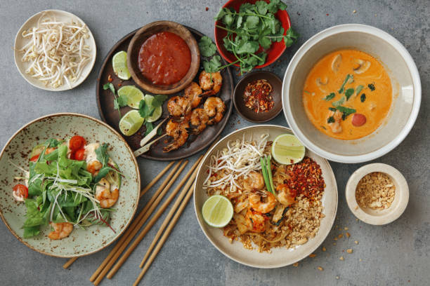 Classic Thai Food Dishes Authentic classic Pad Thai with shrimps. Thai shrimp satay with sweet chili sauce. Tom Yum soup with coconut milk (Tom Khaa). Spicy shrimp salad. Flat lay top-down composition on concrete background. thai food stock pictures, royalty-free photos & images