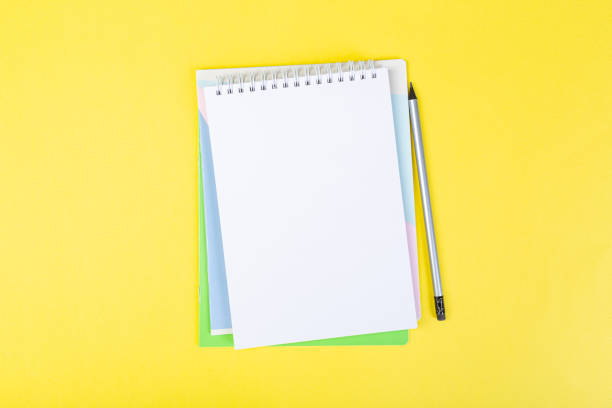 istock open notepad on yellow background with pencil on top, spiral notepad with blank sheet. top view of school concept, work desk of businessman. 1312284842