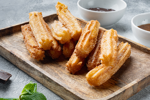 Churros sprinkled with powdered sugar set, on gray background