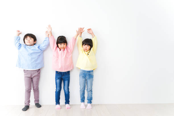 istock Three kindergarteners lined up on the wall 1312285622
