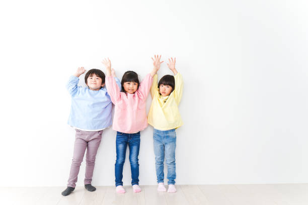 istock Three kindergarteners lined up on the wall 1312285623