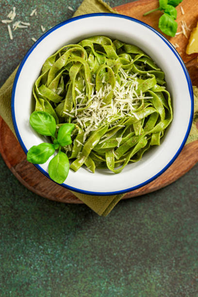 istock Spinach pasta with pesto sauce and grated cheese in a white plate 1312286209