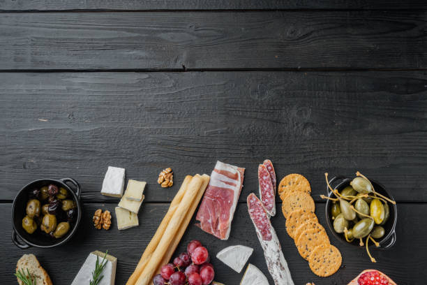 istock Italian snacks, meat cheese, herbs, on black wooden table, top view  with copy space for text 1312286266