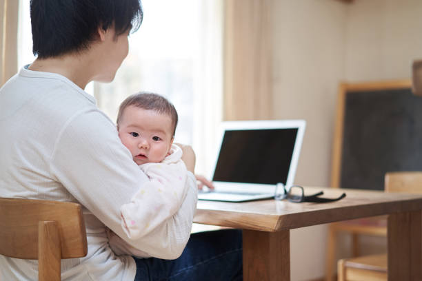 istock Asian dad working while babysittering a baby 1312288387