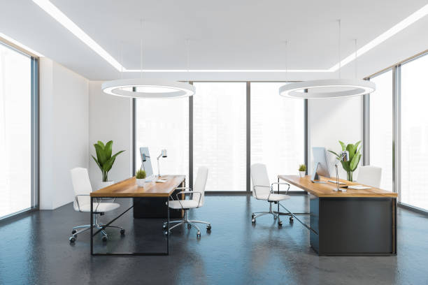 istock Office consulting room with wooden tables and computers, armchairs, windows 1312288816