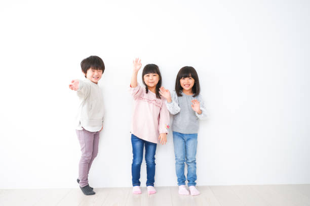 Three children lined up on the wall Three children lined up on the wall korean baby stock pictures, royalty-free photos & images