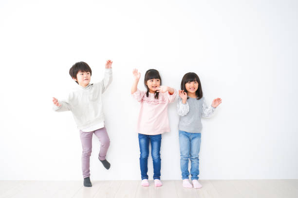 istock Three children lined up on the wall 1312290396
