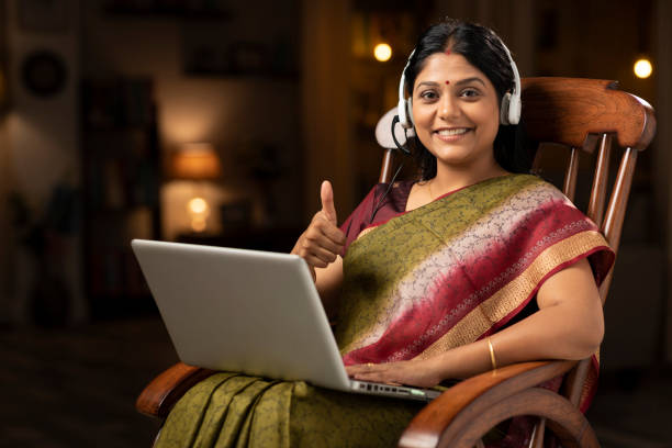 shot of a woman in sari sitting on a rocking chair at home:- stock photo shot of a woman in sari indian teacher stock pictures, royalty-free photos & images