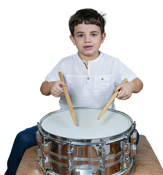 7 year old child learning to play the drums in his first lessons.