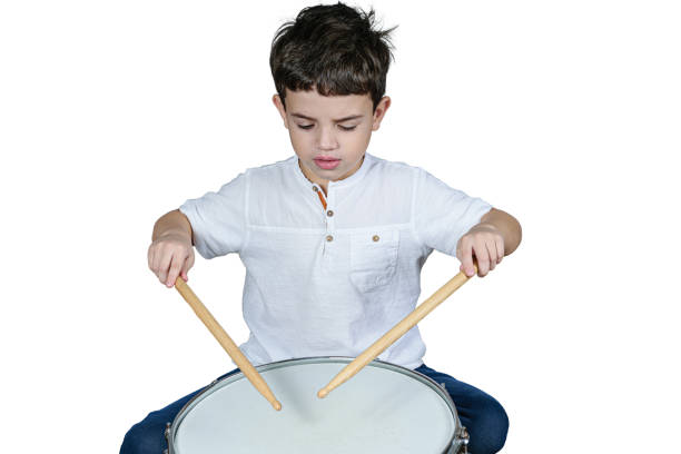 istock 7 year old child focused on his first drum lessons. White background. 1312296646
