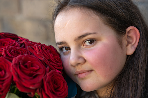 Twelve year old girl with bouquet of red roses