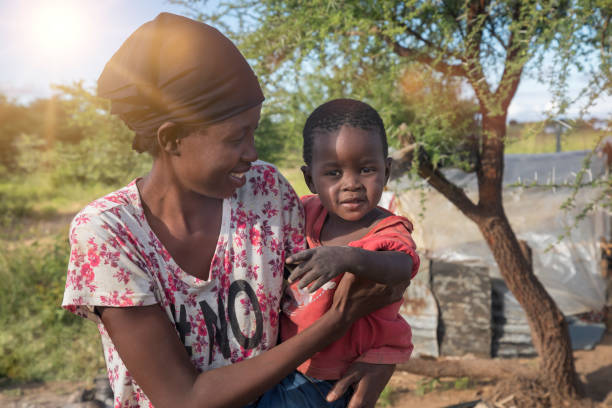 mãe e filhos da família africana juntos - sparse sky sunlight africa - fotografias e filmes do acervo