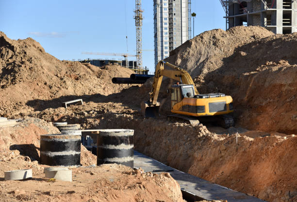 istock Laying heating pipes in trench at construction site. Installing concrete sewer wells and underground storm systems of sanitary water main 1312299968