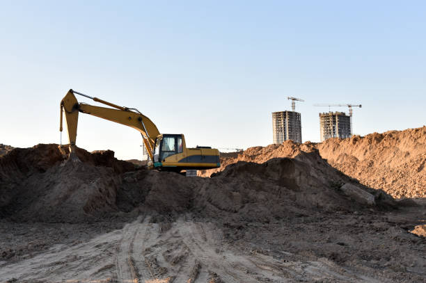 istock Excavator dig trench at construction site. Digging the pit foundation. Laying concrete sewer wells and sewer pipes 1312299969