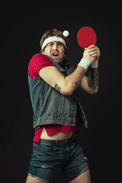 istock Young Caucasian funny man playing ping pong isolated on black background. 1312300122