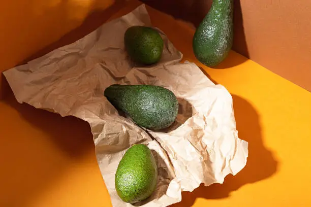 Fresh avocados on lie on a brown background