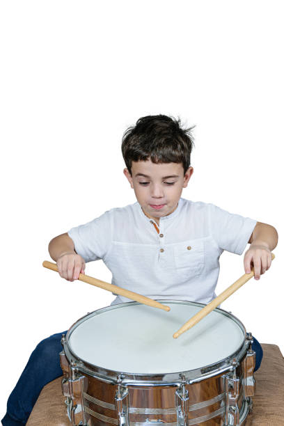 istock 7 year old kid playing the drums and making a funny face. White backgrond. 1312301349