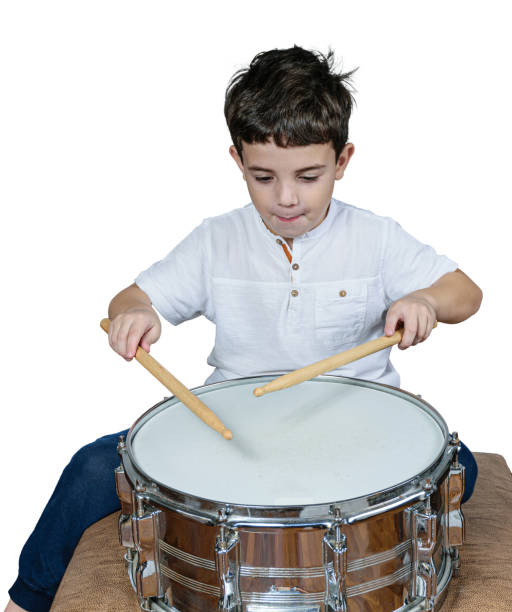 istock 7 year old child concentrated and playing drums. White background. 1312301351