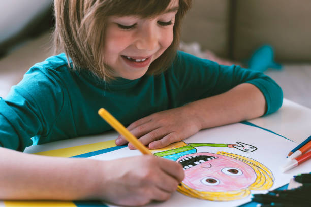 istock Smiling boy drawing at home. Self portrait. 1312301408