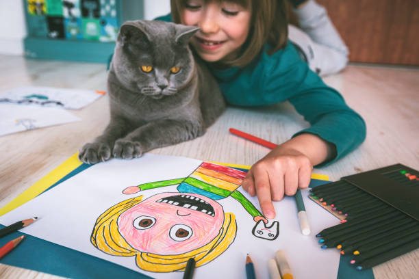 istock Happy boy drawing at home. Cat next to him. Self portrait. 1312301444