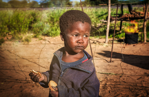 Hungry African child eating biscuits in his village