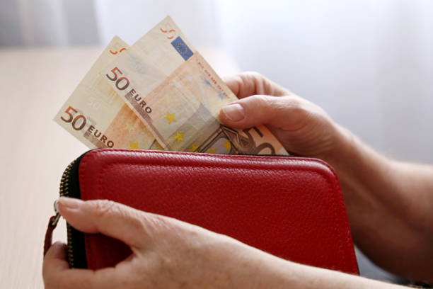 istock Elderly woman takes out a euro note from her wallet 1312302296