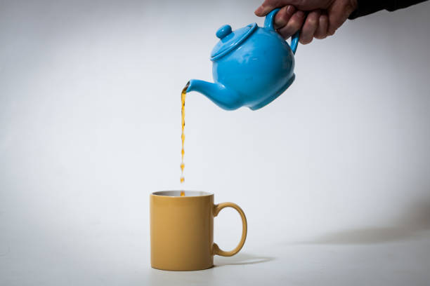 istock A pot of tea being poured into a mug on white backdrop 1312302397