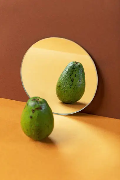 Fresh avocados in mirror reflection