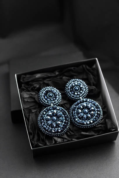 istock Embroidered statement earrings in a gift box on black background 1312303534
