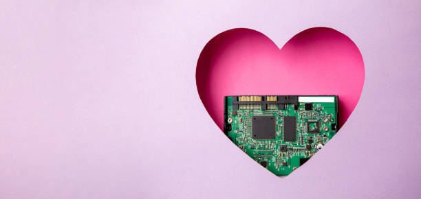 istock The green printed circuit board with microprocessors is located in a pink heart-shaped cavity. All around is purple. 1312303578