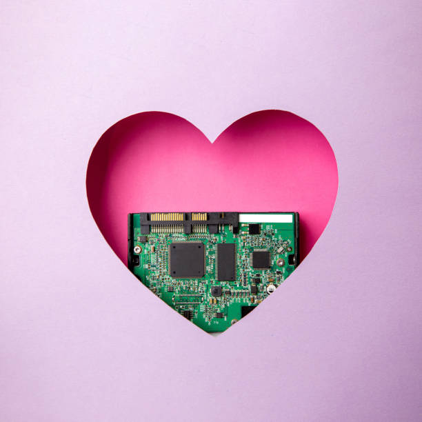 istock The green printed circuit board with microprocessors is located in a pink heart-shaped cavity. All around is purple. 1312303626