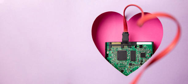 istock The green printed circuit board with microprocessors is located in a pink heart-shaped cavity. All around is purple. 1312303901