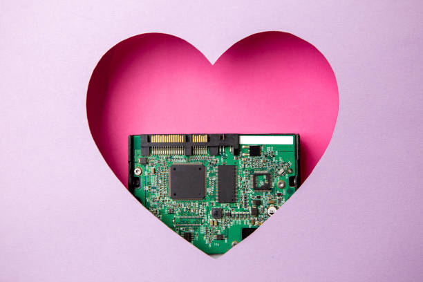 istock The green printed circuit board with microprocessors is located in a pink heart-shaped cavity. All around is purple. 1312303968