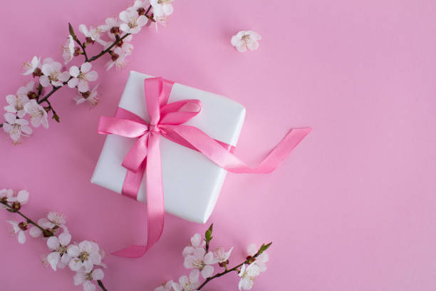 istock Gift with pink bow and flowering tree branches on the pink background.Top view.Copy space. 1312304037